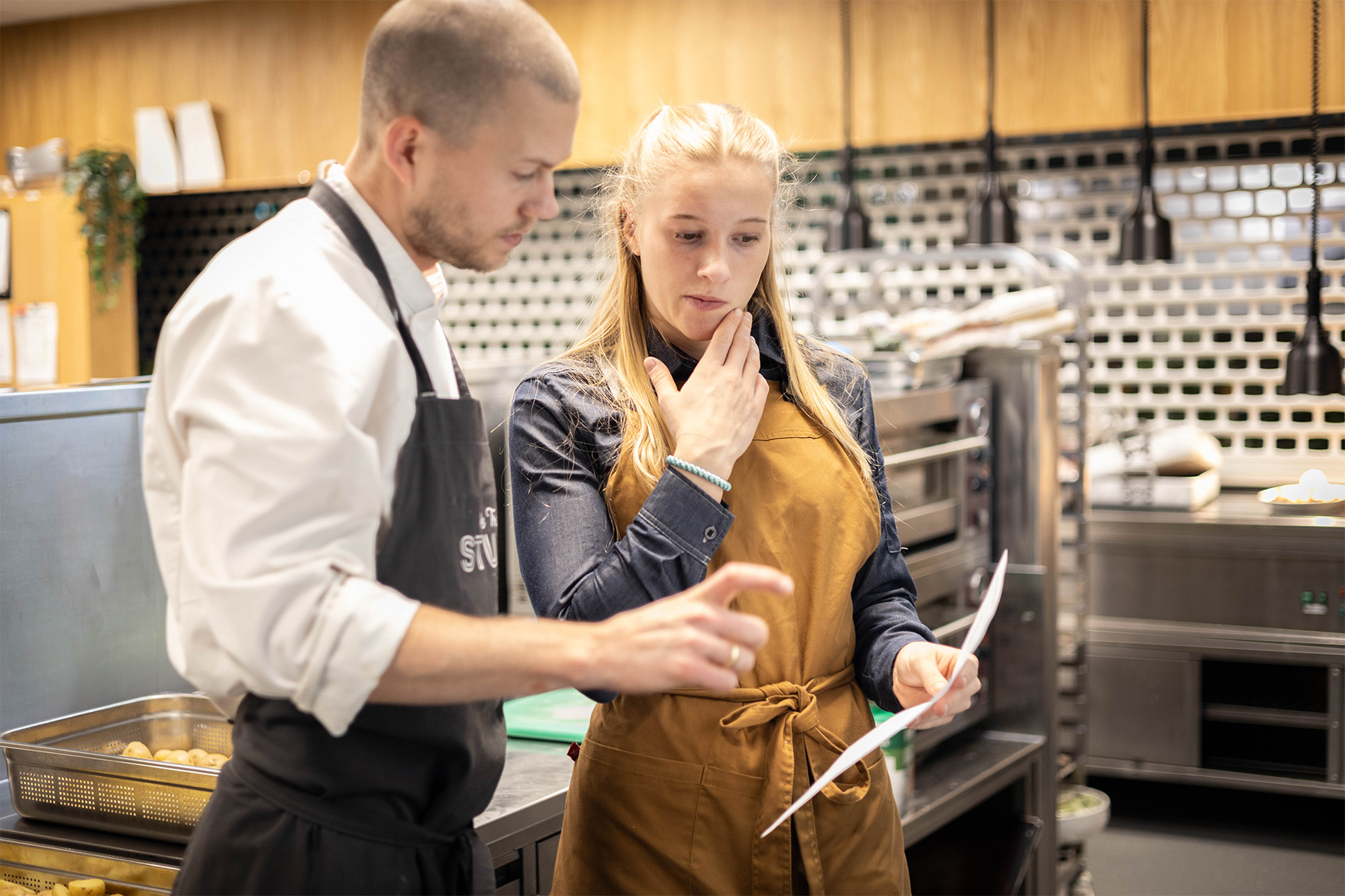 en mann og en dame som diskuterer inne på et kjøkken